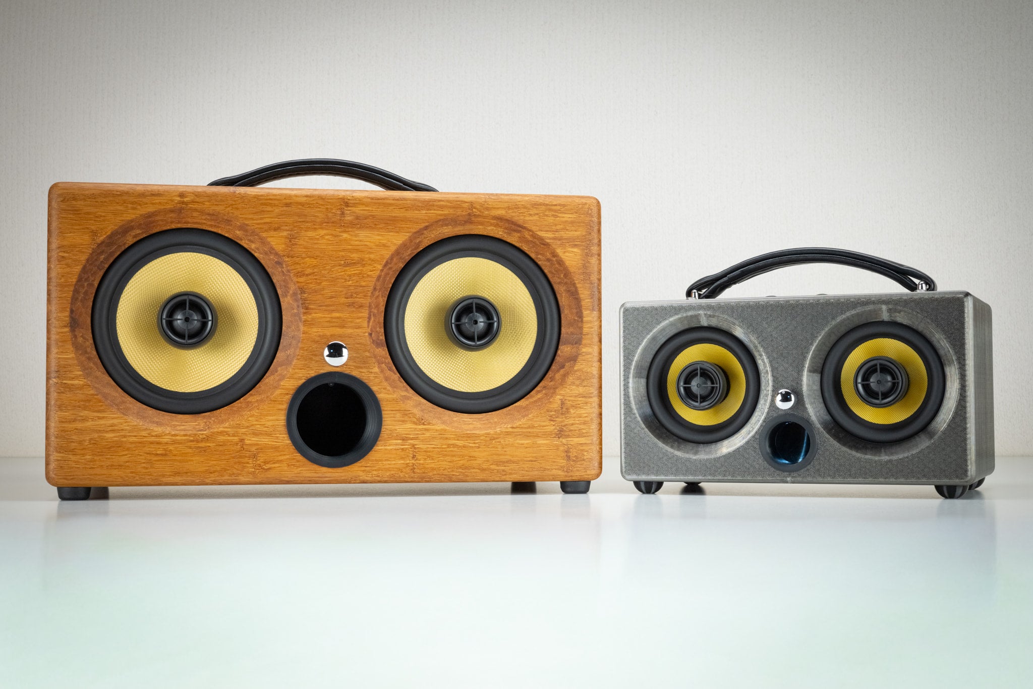 Grey Thodio iBox Mini 3D-printed speaker next to the larger handmade bamboo iBox, showing size comparison