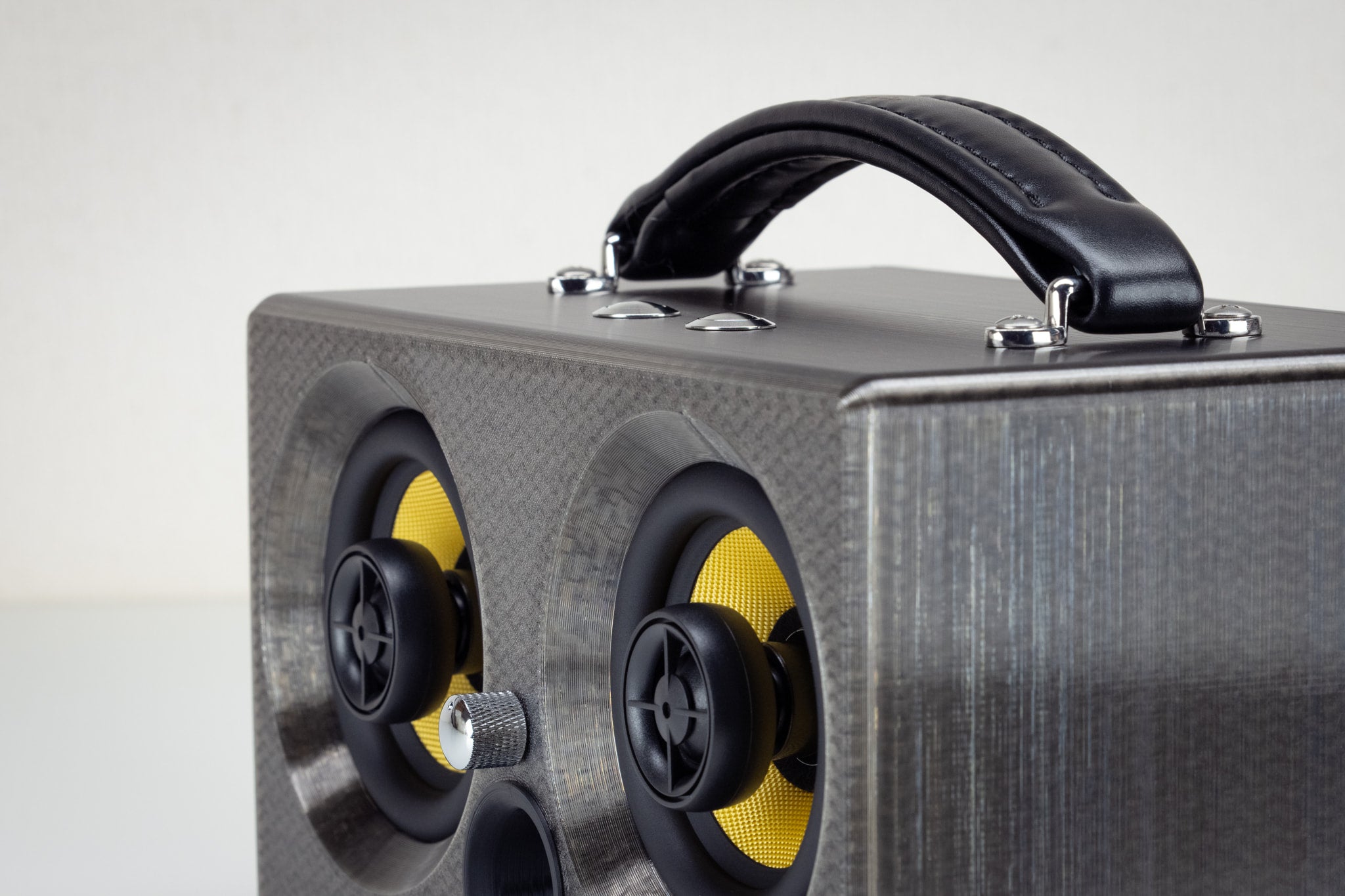 Corner detail of the grey Thodio iBox Mini 3D-printed audiophile speaker showing the twin coaxial drivers and volume knob