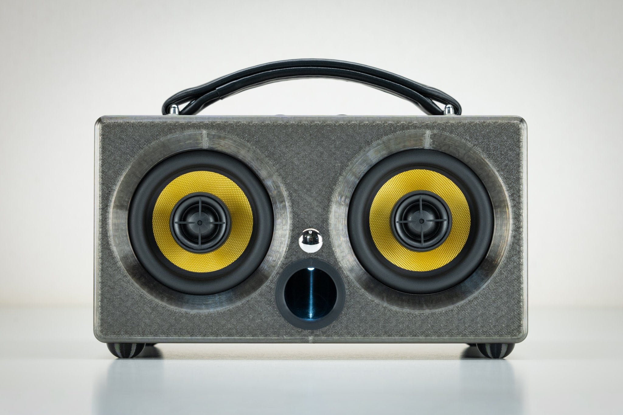 Front view of the grey gunmetal Thodio iBox Mini 3D-printed Bluetooth speaker with twin yellow drivers and central bass port