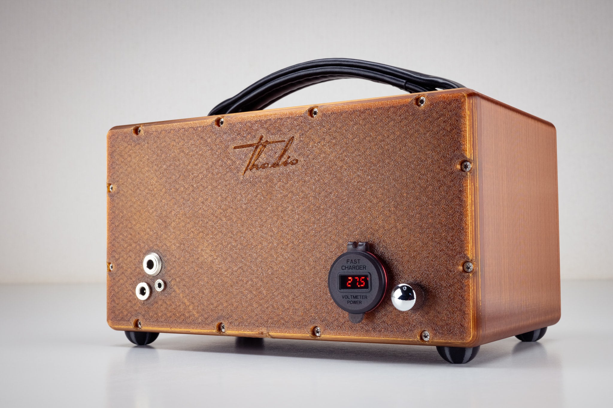 Back of the amber Thodio iBox Mini 3D-printed speaker showing USB fast charger, power voltmeter, aux input jacks and embossed Thodio logo
