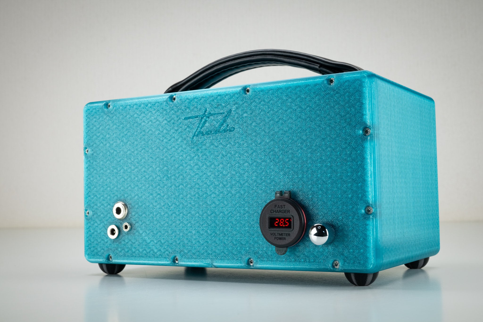 Back of the turquoise Thodio iBox Mini 3D-printed speaker showing USB fast charger, power voltmeter, aux input jacks and embossed Thodio logo