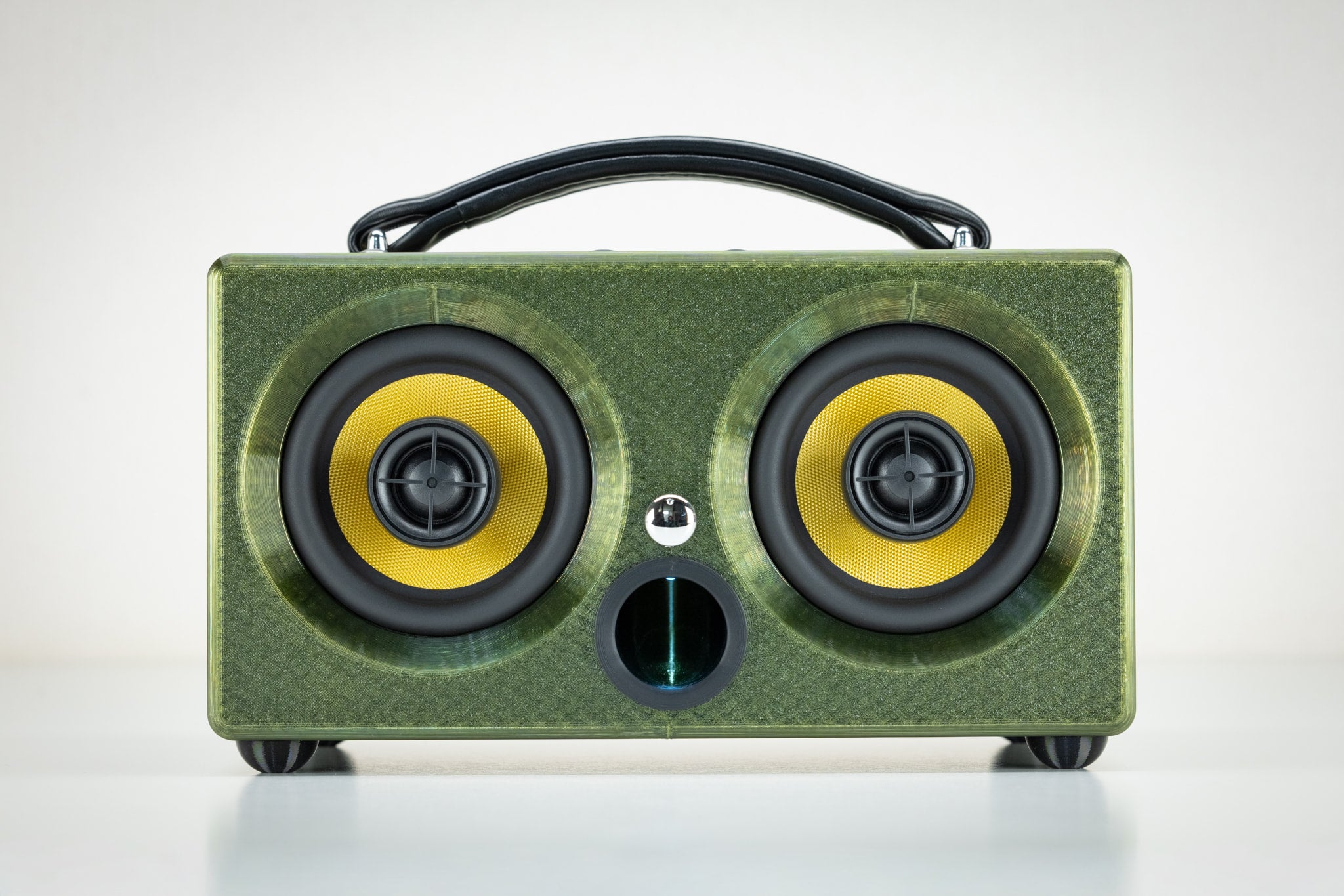 Front view of the Thodio 3D-printed portable Bluetooth speaker in green with twin yellow audiophile drivers and bass port