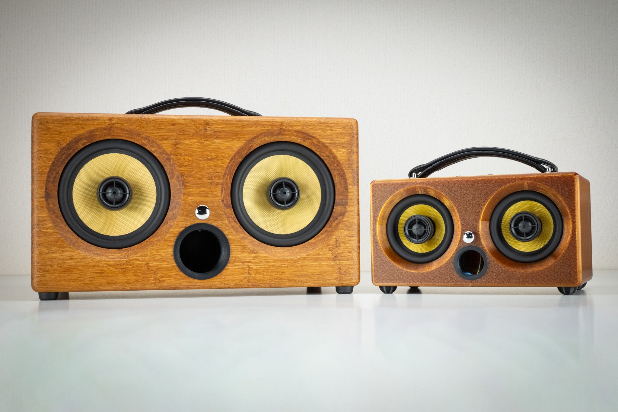 Amber Thodio iBox Mini 3D-printed speaker next to the larger handmade bamboo iBox, showing size comparison