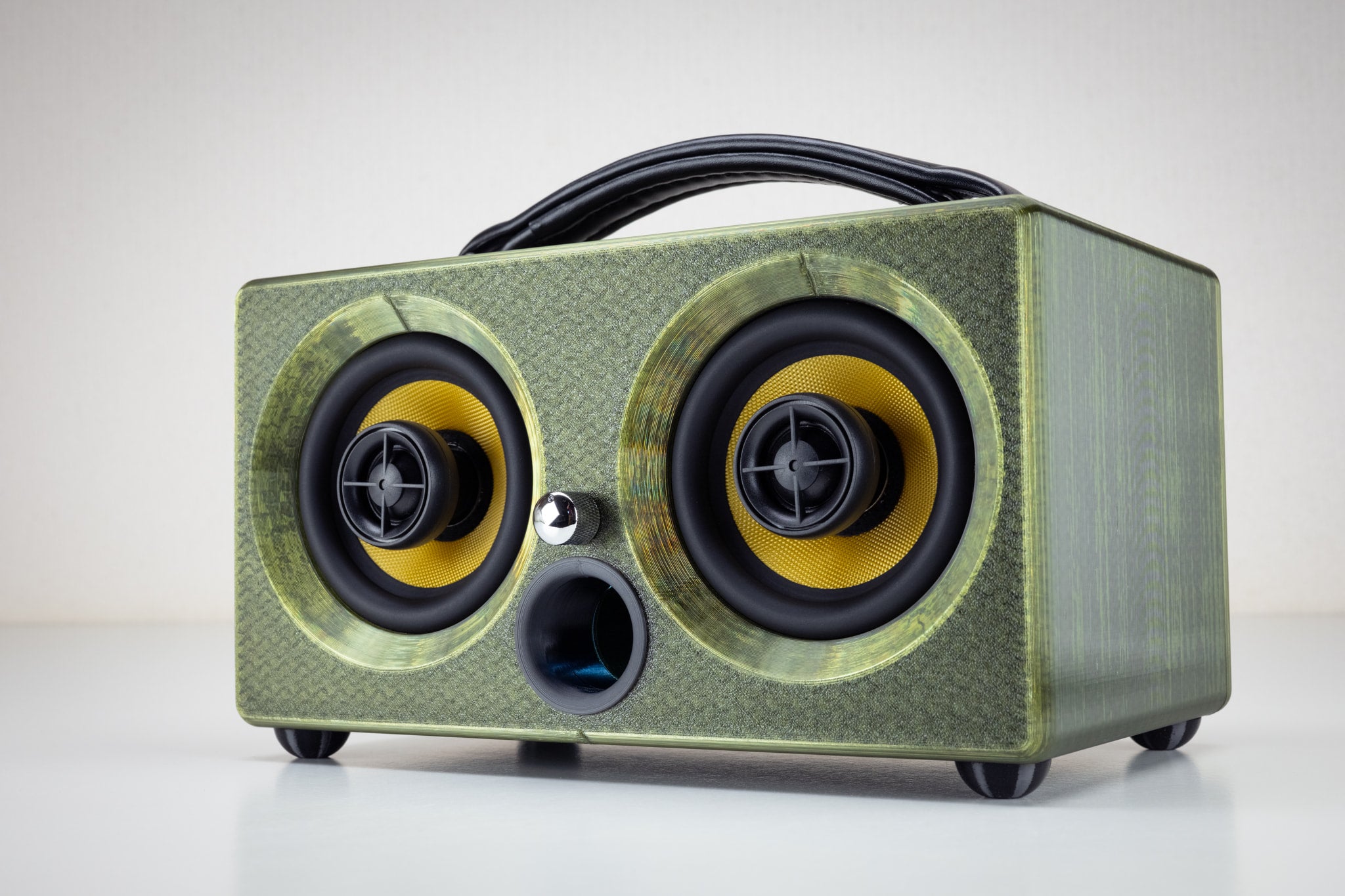 Thodio iBox Mini 3D-printed portable Bluetooth speaker in emerald green, front three-quarter view showing twin coaxial drivers and leather handle