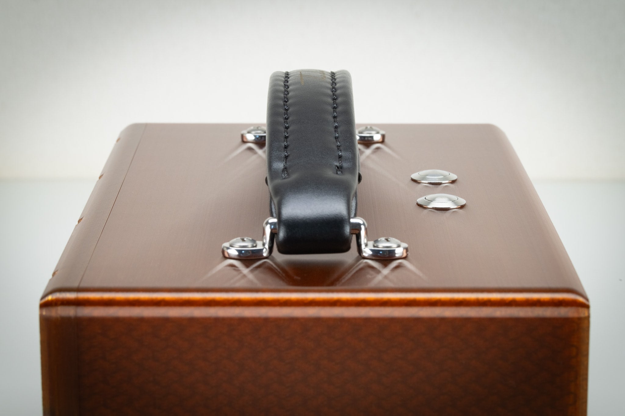 Close detail of the padded leather carry handle and chrome buttons on the amber Thodio iBox Mini 3D-printed speaker