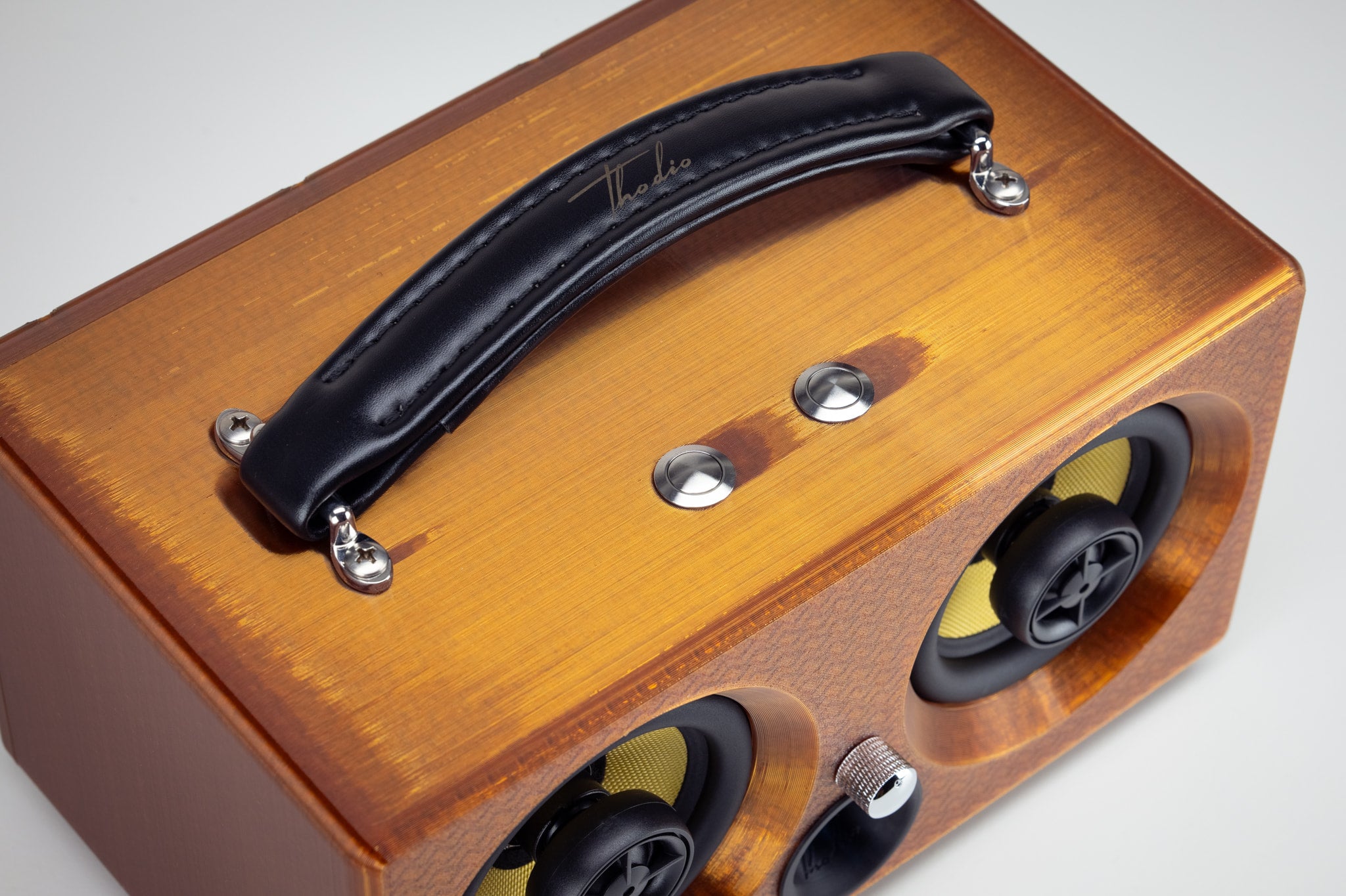 Top view of the amber Thodio iBox Mini 3D-printed Bluetooth speaker with padded leather carry handle and chrome control buttons