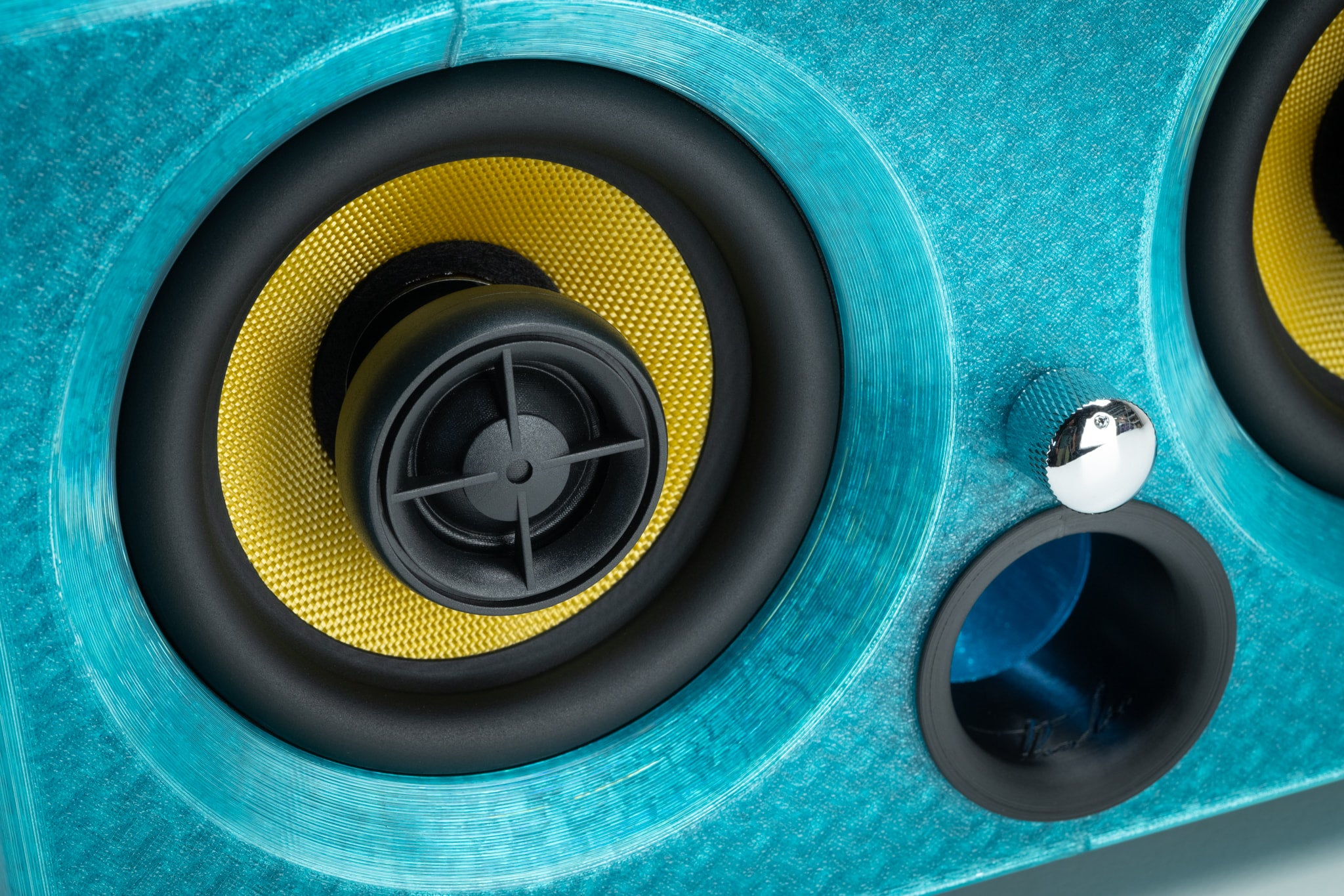 Macro detail of the turquoise Thodio iBox Mini driver showing the Kevlar coaxial cone, silk-dome tweeter and bass-reflex port