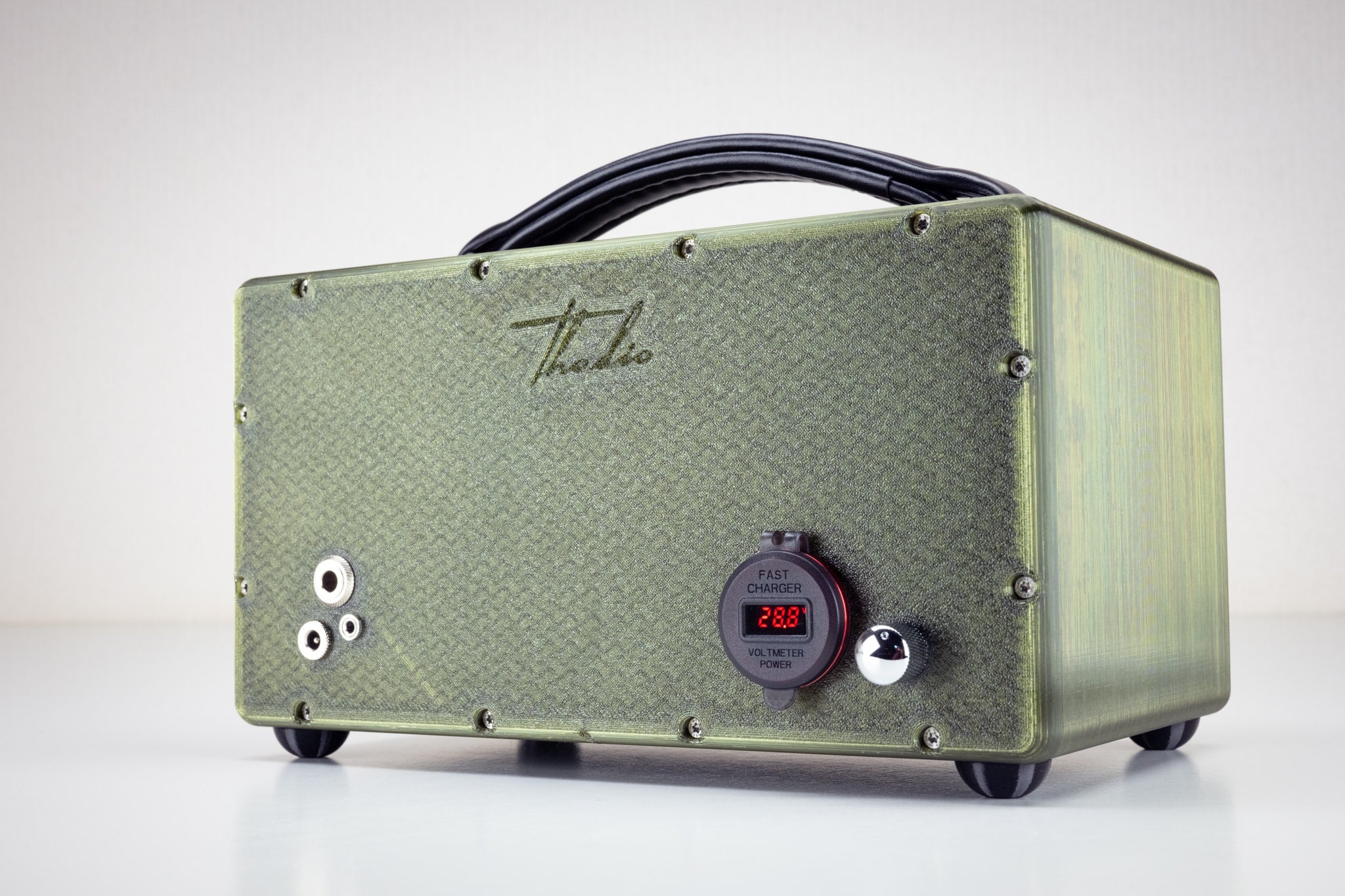 Back of the Thodio 3D-printed wireless speaker showing the USB fast charger, power voltmeter, aux input jacks and embossed Thodio logo 